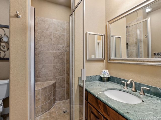 bathroom with vanity, toilet, and a shower with door