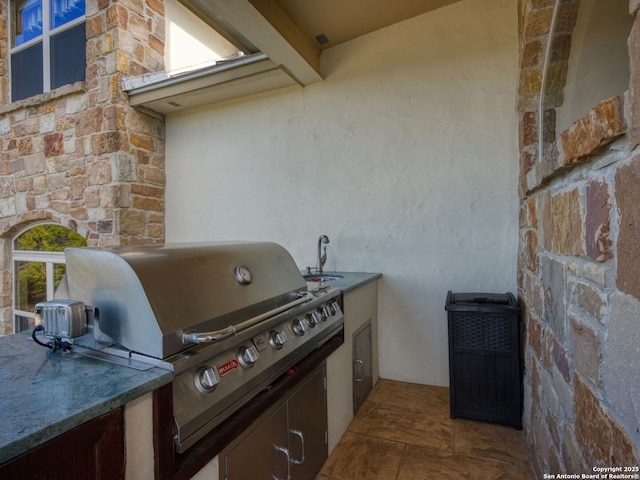 view of patio with exterior kitchen and a grill