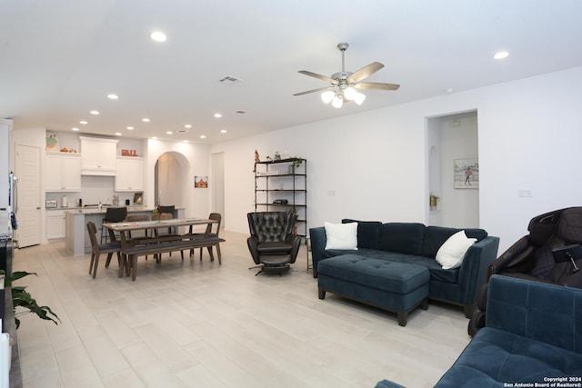 living room with ceiling fan and light hardwood / wood-style flooring