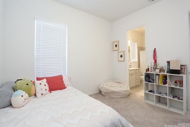 carpeted bedroom featuring ensuite bath