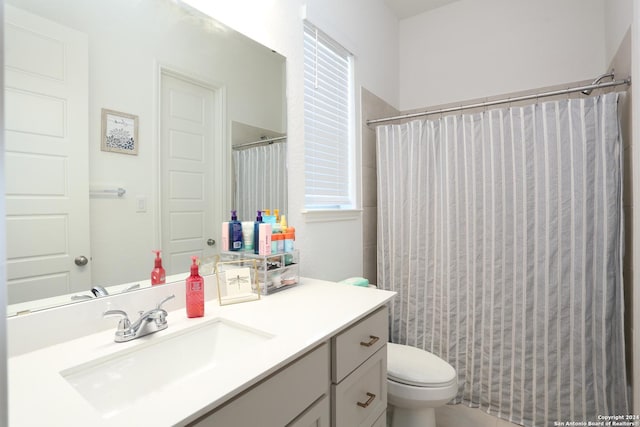 bathroom featuring curtained shower, vanity, and toilet