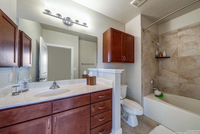 full bathroom featuring tile patterned flooring, vanity, tiled shower / bath combo, and toilet