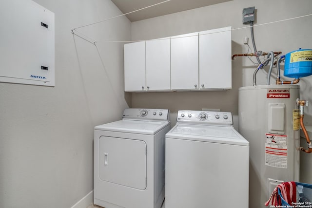 washroom featuring independent washer and dryer, cabinets, and water heater