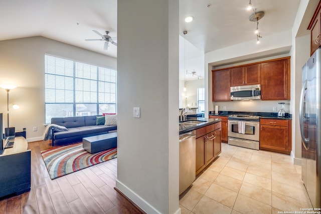 kitchen featuring sink, vaulted ceiling, light tile patterned floors, appliances with stainless steel finishes, and ceiling fan