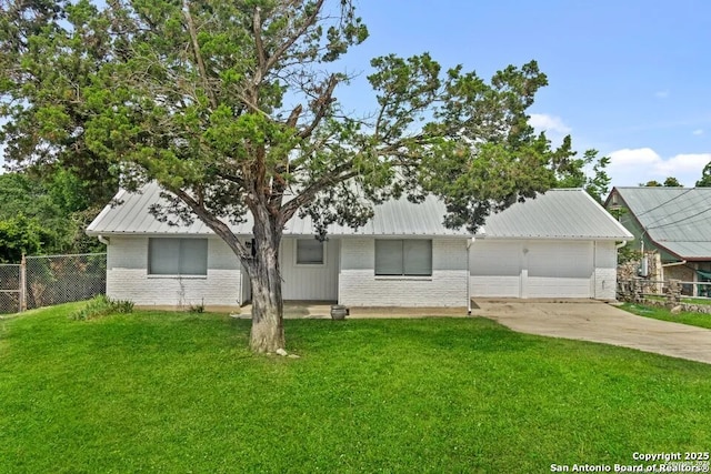 ranch-style home featuring a garage and a front lawn