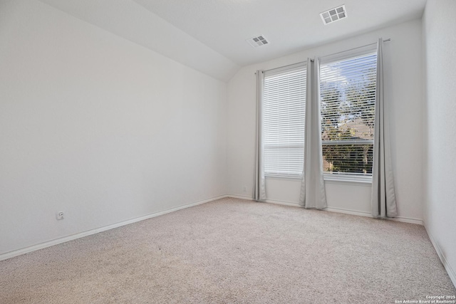 spare room featuring carpet and vaulted ceiling