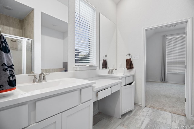 bathroom featuring vanity and a shower with door