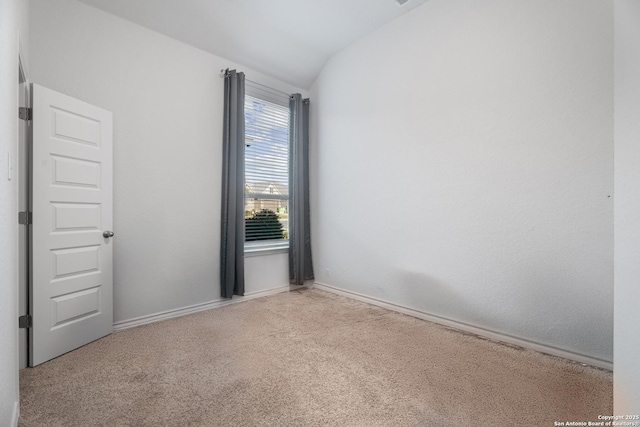 spare room with light carpet and lofted ceiling