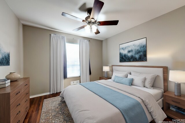 bedroom with dark hardwood / wood-style flooring and ceiling fan