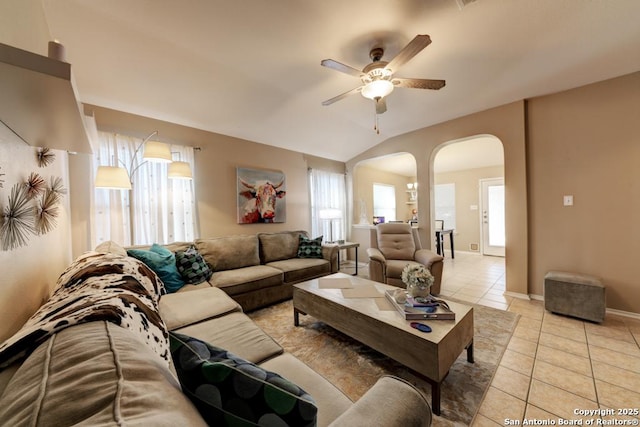 living room featuring ceiling fan, lofted ceiling, and light tile patterned flooring