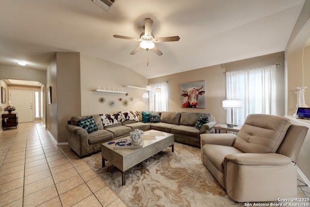 living room featuring ceiling fan, light tile patterned floors, and lofted ceiling