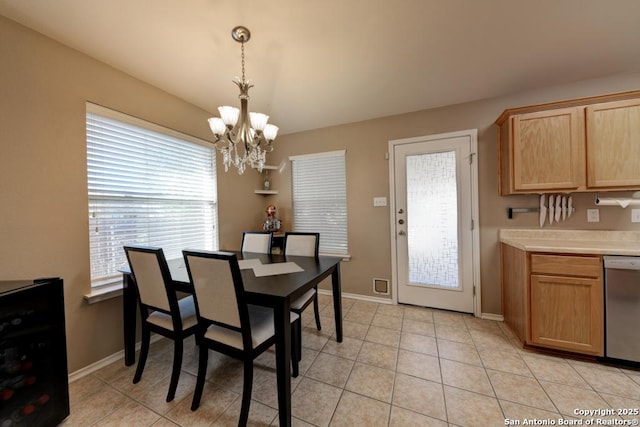 tiled dining space featuring plenty of natural light and a notable chandelier