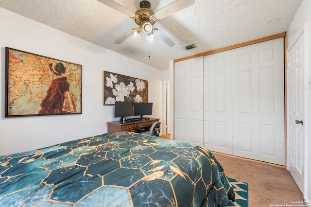 carpeted bedroom featuring a textured ceiling, a closet, and ceiling fan