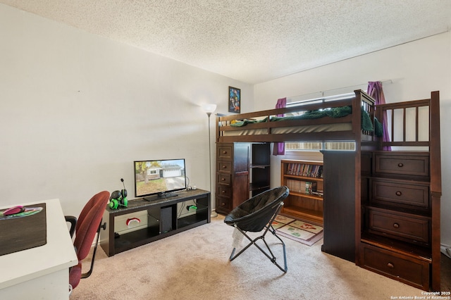 bedroom with light colored carpet and a textured ceiling