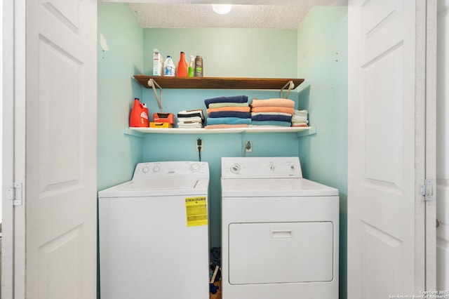 laundry area with a textured ceiling and separate washer and dryer