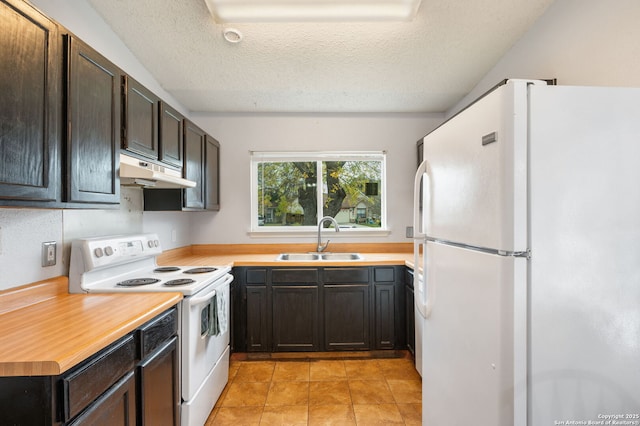 kitchen with white appliances, sink, light tile patterned floors, a textured ceiling, and dark brown cabinets