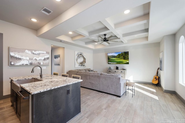 living room featuring coffered ceiling, sink, ceiling fan, light wood-type flooring, and beam ceiling