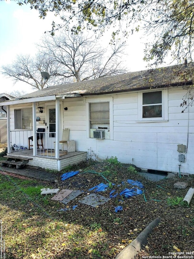 single story home with cooling unit and a porch