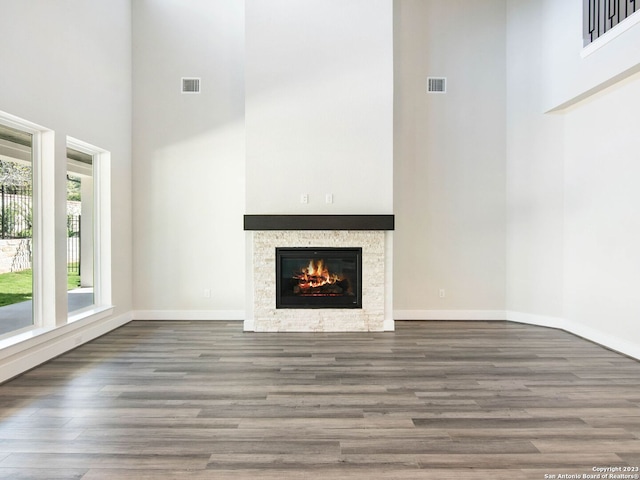 unfurnished living room with a towering ceiling and dark wood-type flooring