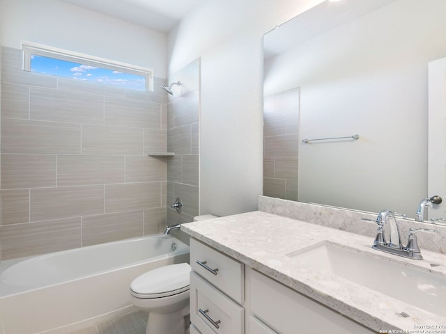 full bathroom featuring vanity, tiled shower / bath combo, and toilet