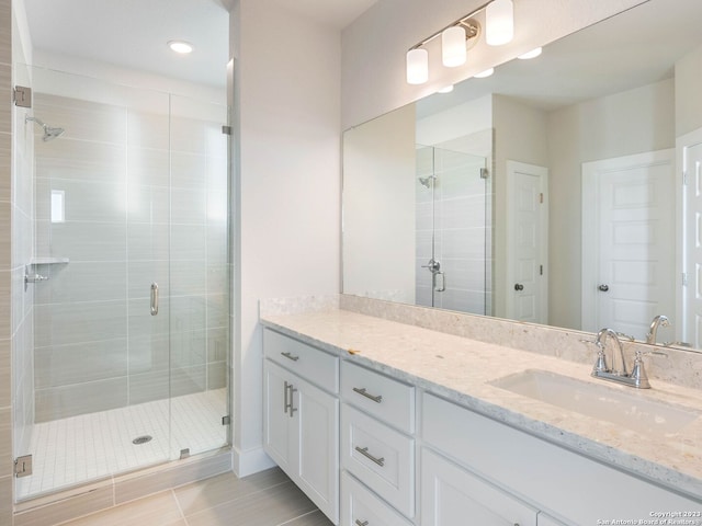 bathroom with tile patterned flooring, vanity, and a shower with shower door