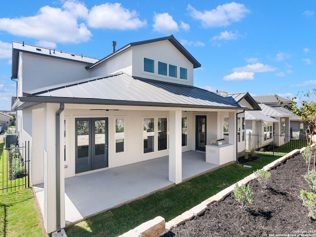 rear view of house with ceiling fan, french doors, and a patio