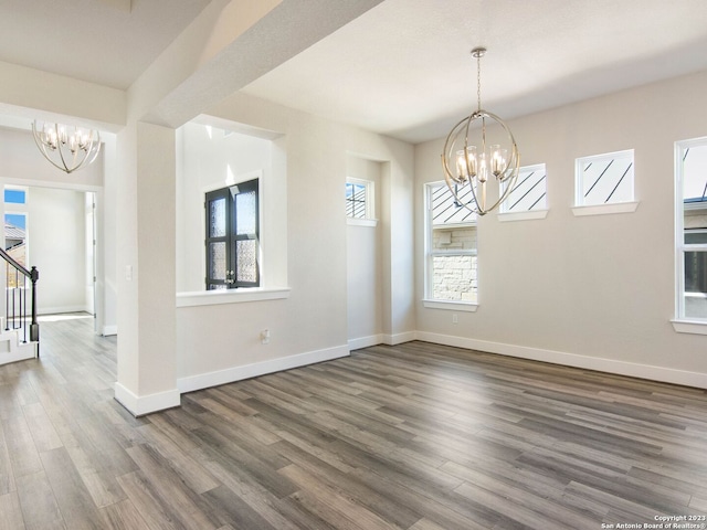 unfurnished dining area featuring dark wood-type flooring and a notable chandelier