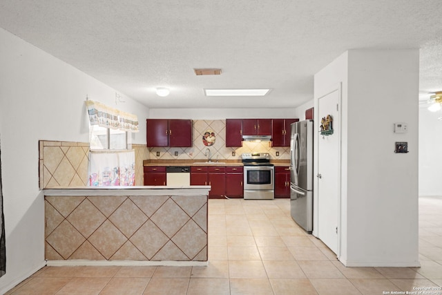 kitchen with decorative backsplash, a textured ceiling, stainless steel appliances, sink, and light tile patterned flooring