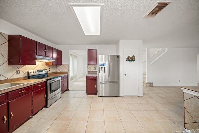 kitchen with backsplash, sink, light tile patterned floors, and stainless steel appliances