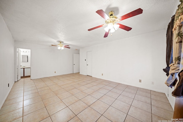 unfurnished living room with ceiling fan, light tile patterned flooring, and a textured ceiling