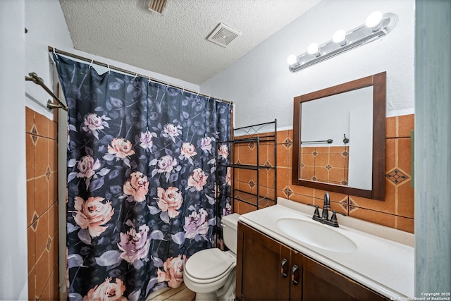 bathroom with vanity, toilet, and a textured ceiling