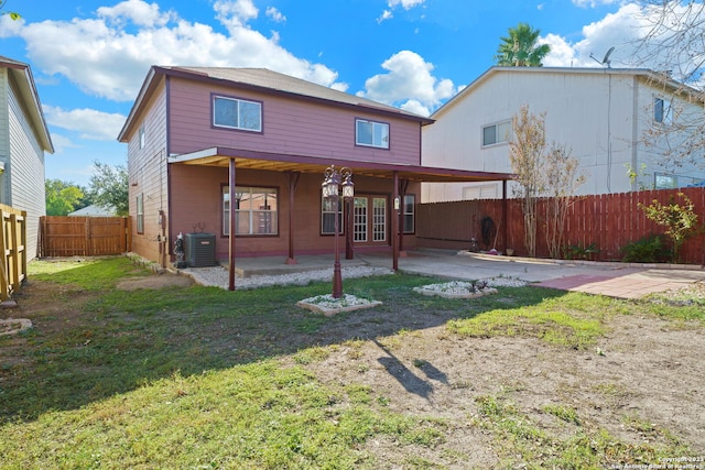 back of property featuring a lawn, a patio area, french doors, and central AC