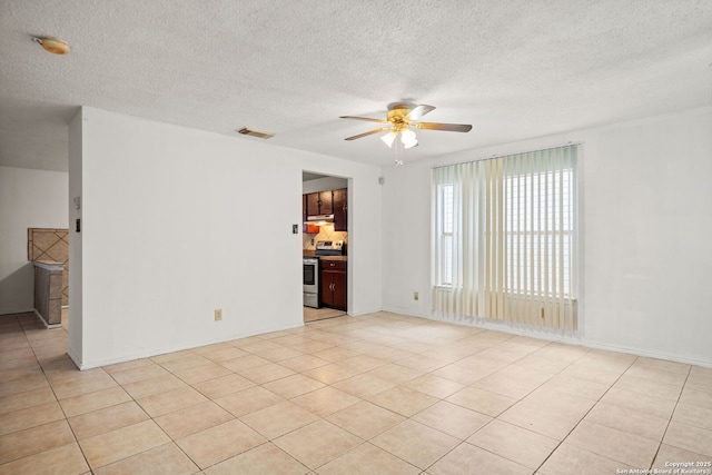 tiled spare room featuring a textured ceiling and ceiling fan