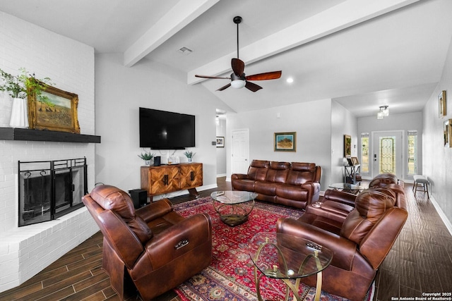 living room with vaulted ceiling with beams, ceiling fan, and a brick fireplace