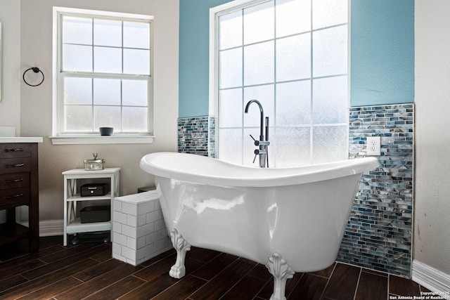 bathroom with a wealth of natural light and a tub