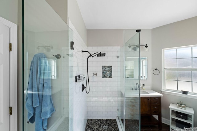 bathroom featuring a shower with door and vanity