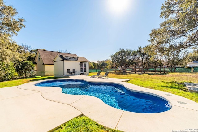 view of swimming pool featuring a lawn and an outdoor structure