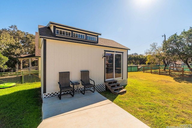 rear view of property featuring a yard and a patio