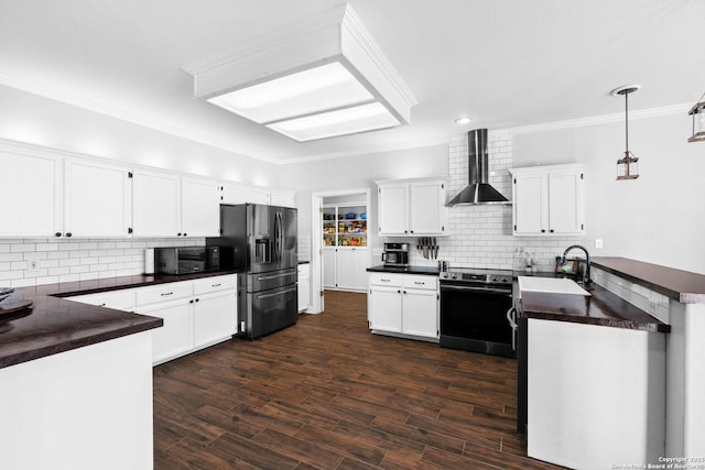 kitchen with wall chimney range hood, white cabinets, kitchen peninsula, and electric stove