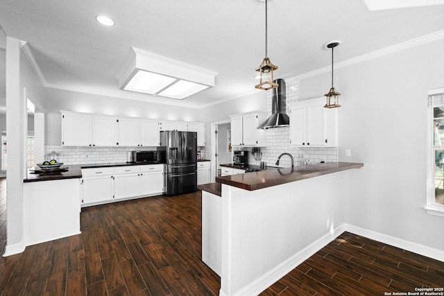 kitchen with white cabinets, stainless steel refrigerator with ice dispenser, kitchen peninsula, and wall chimney exhaust hood