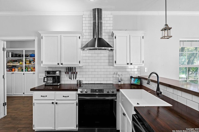 kitchen with white cabinets, stainless steel range with electric cooktop, and wall chimney range hood