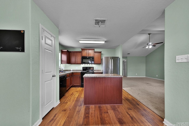 kitchen with ceiling fan, dark hardwood / wood-style floors, a textured ceiling, a kitchen island, and black appliances