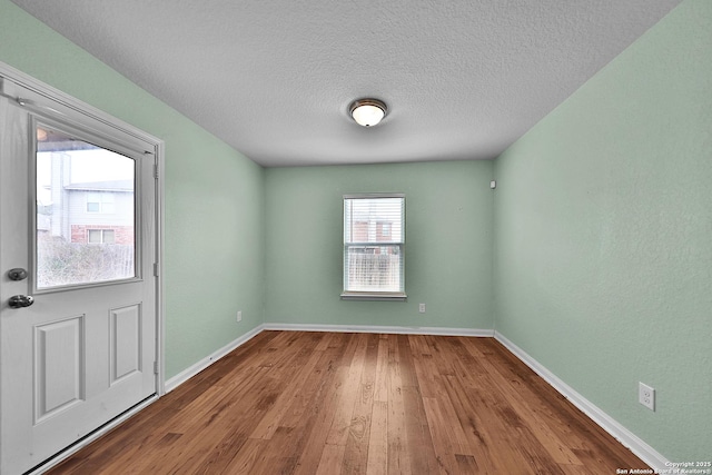 empty room with a textured ceiling and hardwood / wood-style flooring