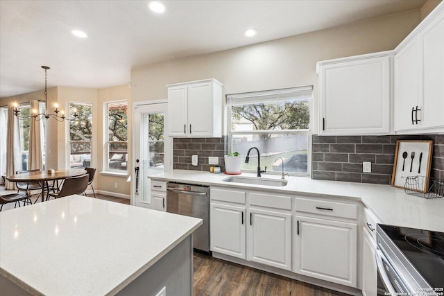 kitchen with sink, stainless steel appliances, an inviting chandelier, tasteful backsplash, and white cabinets