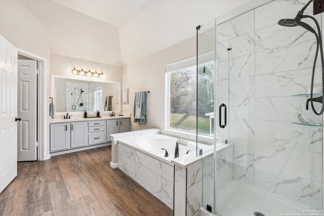 bathroom featuring vaulted ceiling, vanity, shower with separate bathtub, and hardwood / wood-style flooring