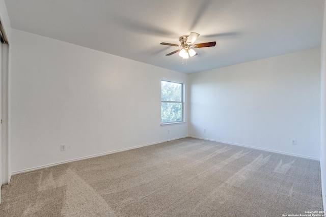 carpeted spare room featuring ceiling fan