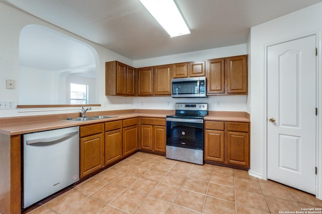 kitchen with light tile patterned floors, sink, and appliances with stainless steel finishes