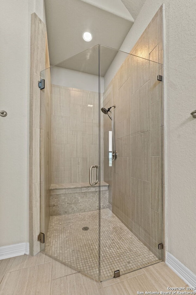 bathroom featuring a shower with door