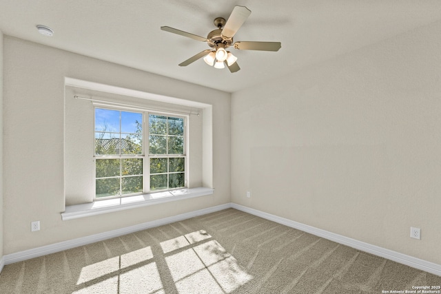 carpeted spare room featuring ceiling fan