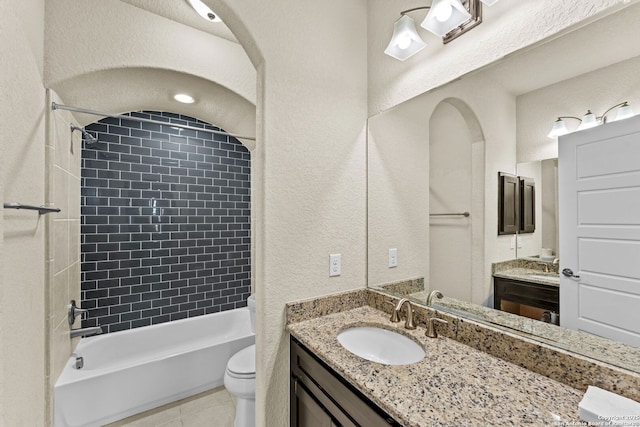 full bathroom featuring tile patterned flooring, vanity, toilet, and tiled shower / bath